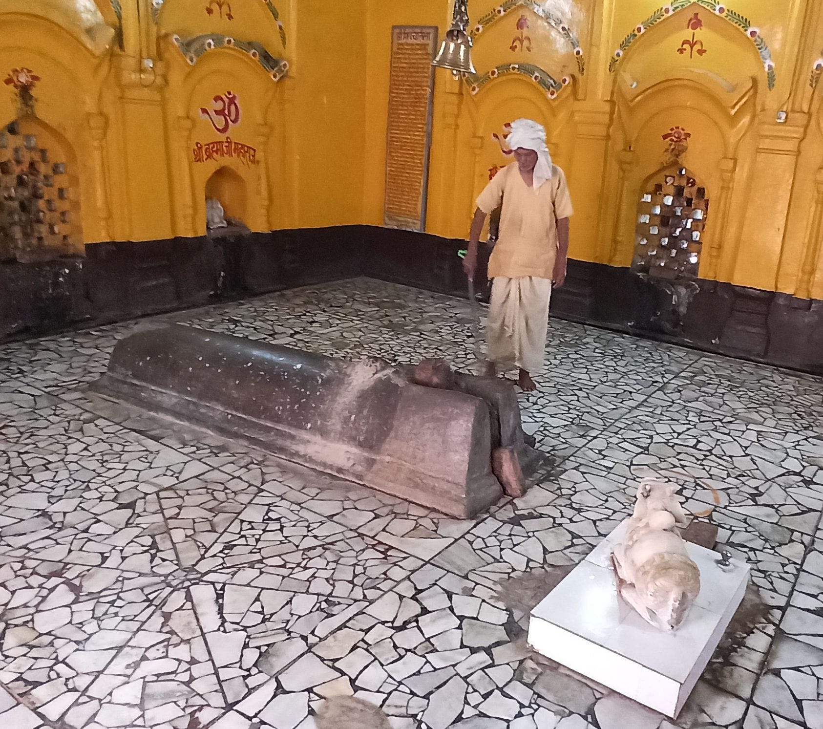 डेरापुर के कपालेश्वर मंदिर की सफाई करते महंत रामसजीवन दास।