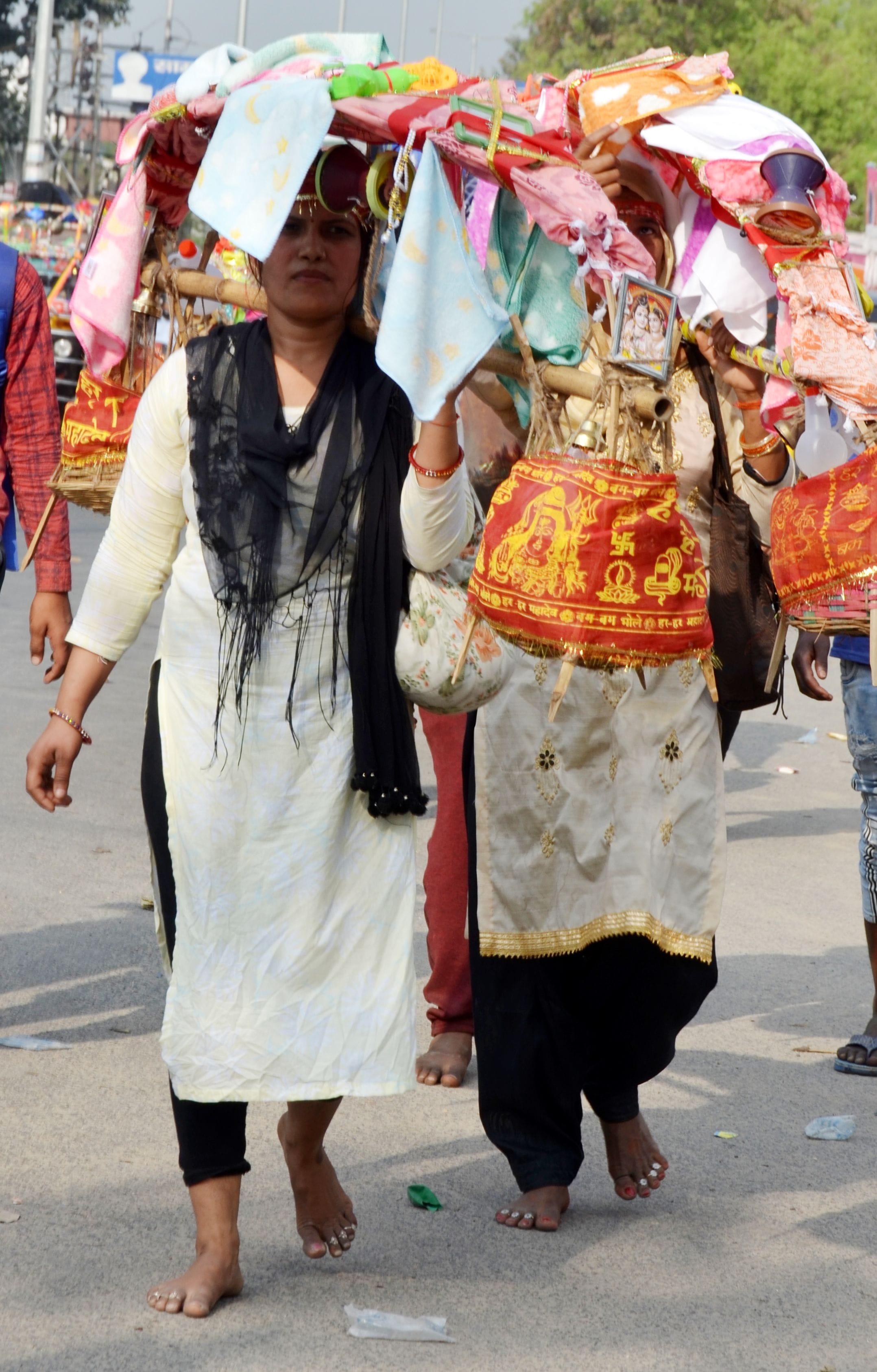 रामघाट रोड़ पर नंगे पैर कांवड लेकर जाती शिव भक्त। रामघाट रोड़ पर नंगे पैर कांवड लेकर जाती शिव भक्त।