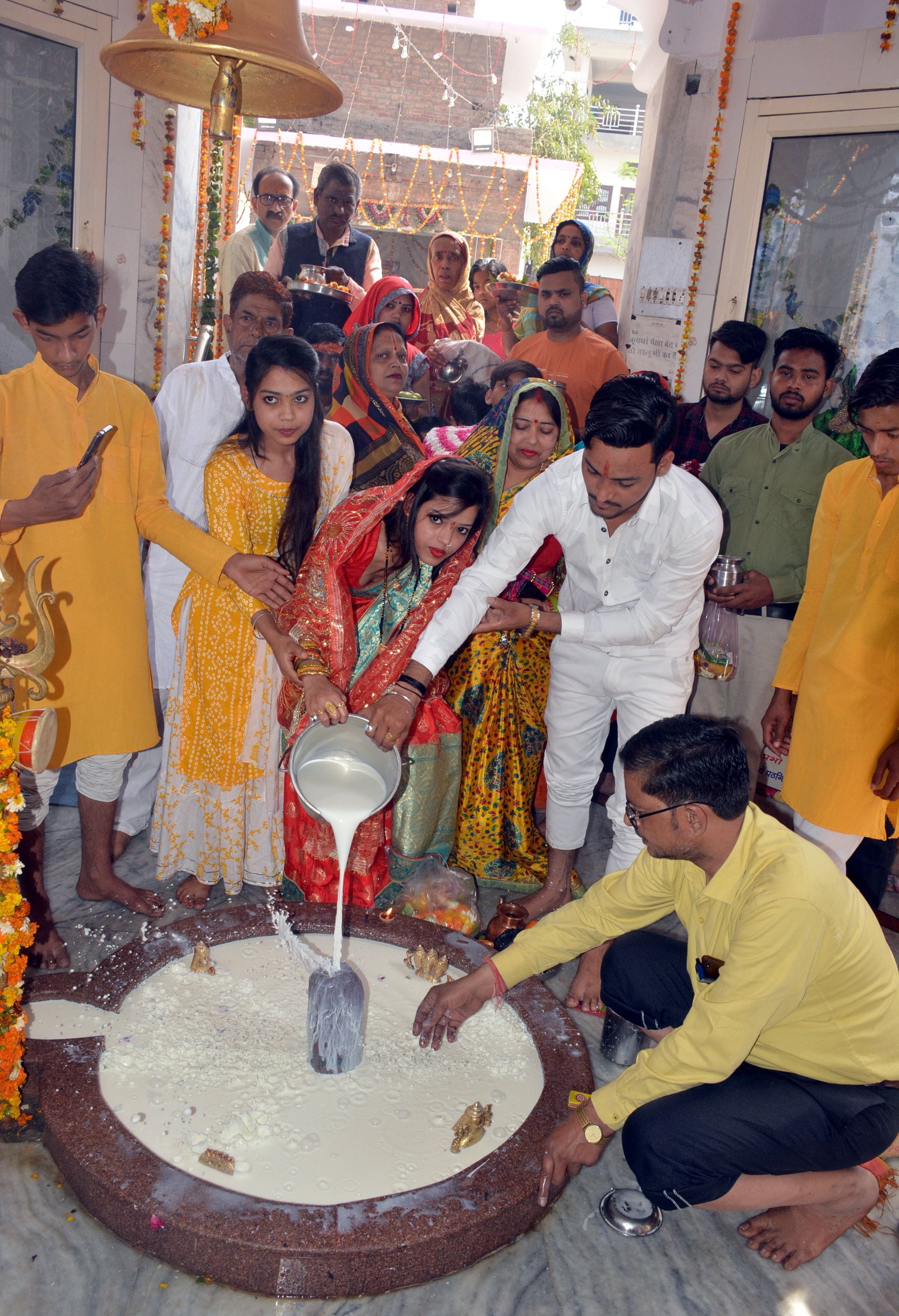 श्री मंगलेश्वर महादेव मंदिर में दुग्धाभिषेक करते श्रद्धालु।