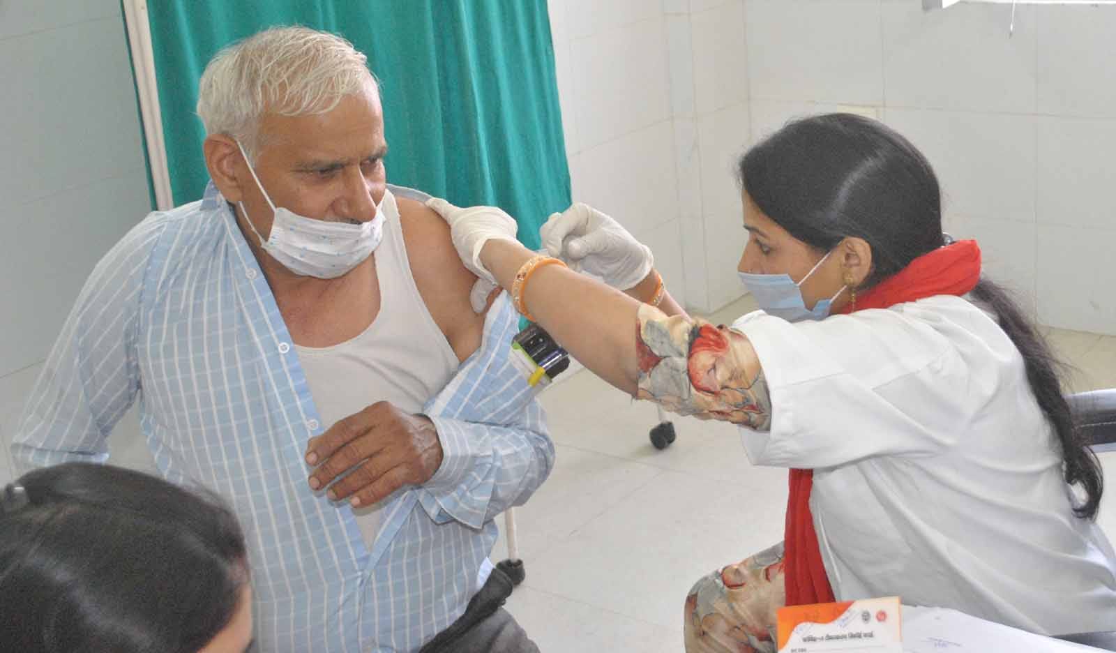 शामली के जिला अस्पताल में टीका लगवाता वृद्घ।