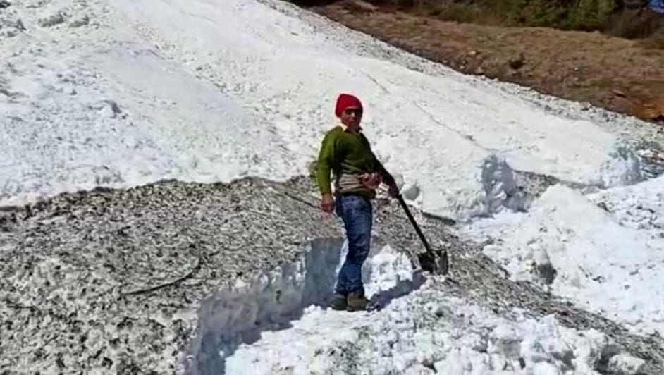 सेला बालिंग सड़क से बर्फ हटाता युवक। सेला बालिंग सड़क से बर्फ हटाता युवक।
