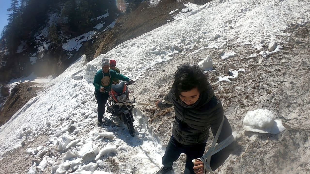 गलछिन नाले में ग्लेशियर आने के बाद रस्सी से बाइक को खींचते युवा। गलछिन नाले में ग्लेशियर आने के बाद रस्सी से बाइक को खींचते युवा।