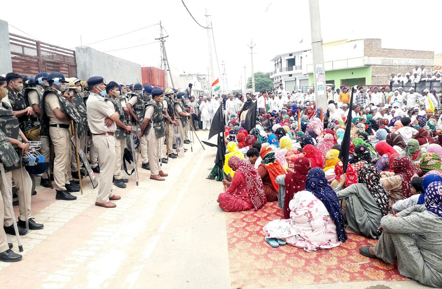 जेजेपी कार्यालय के मुख्य गेट पर खड़े पुलिसकर्मी और उसके आगे धरना देते किसान। संवाद। जेजेपी कार्यालय के मुख्य गेट पर खड़े पुलिसकर्मी और उसके आगे धरना देते किसान। संवाद।