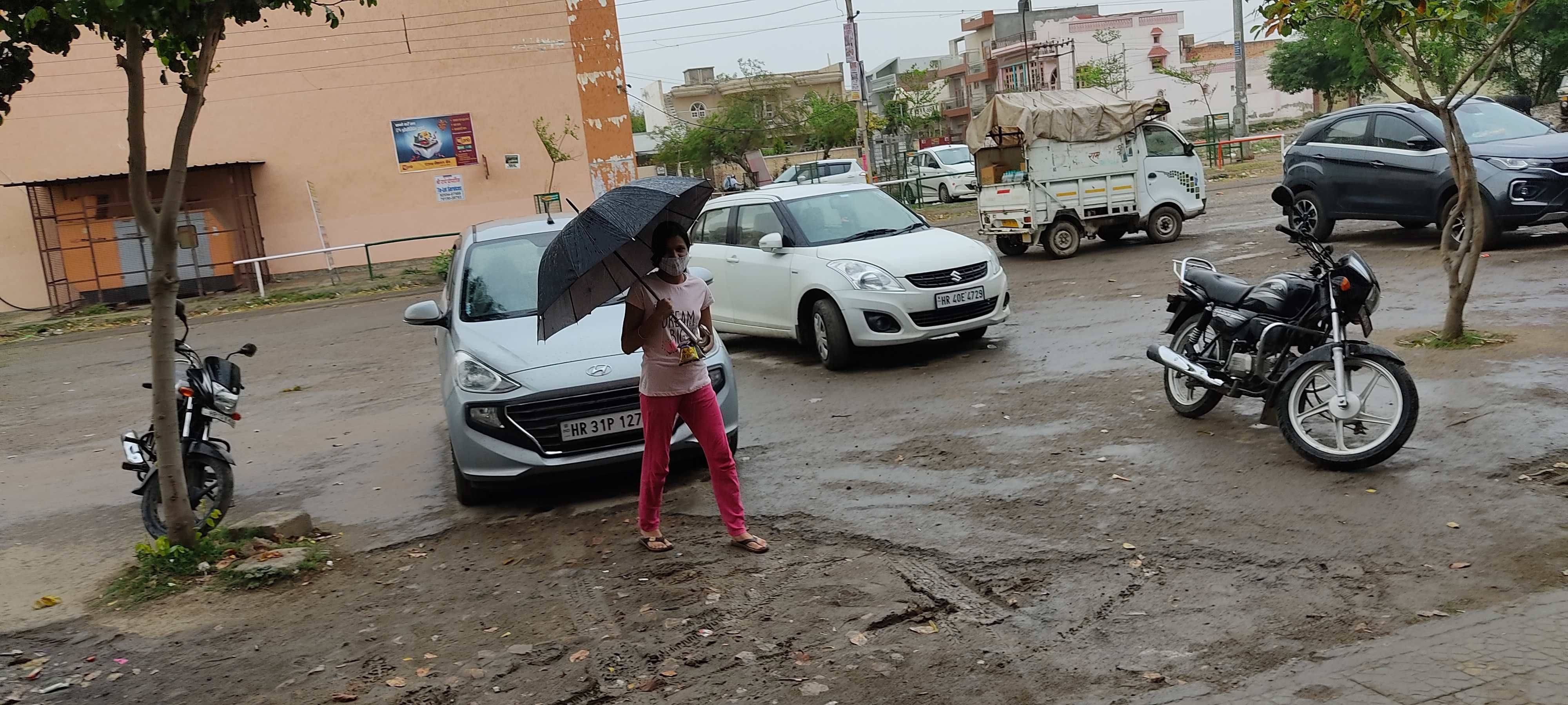  बारिश से बचने के लिए छाता लेकर जाती लड़की। 