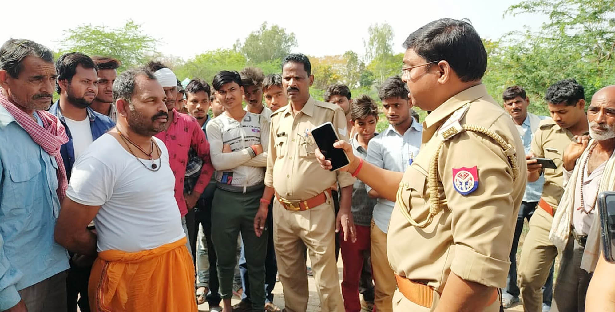 उर्दना गांव में सड़क जाम किए ग्रामीणों को समझाते कोतवाल तारा सिंह पटेल। संवाद