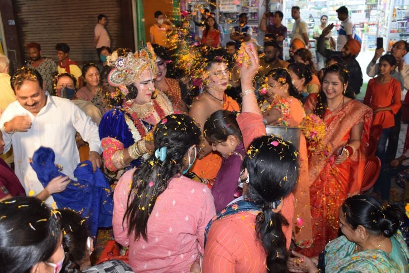 रुद्रपुर के दुर्गा मंदिर में कलाकारों के साथ फूलों की होली खेलते लोग।