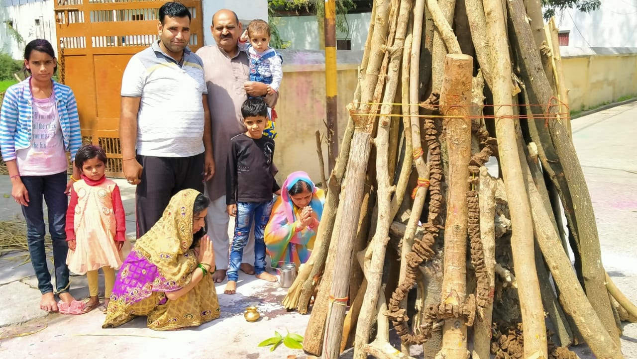 धामपुर में होलिका पूजन करतीं महिलाएं। धामपुर में होलिका पूजन करतीं महिलाएं।