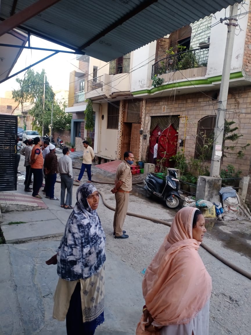 प्रेमपुरी कॉलोनी में नमकीन फैक्टरी में लगी आग के दौरान घरों के बाहर खड़े लोग व दमकल कर्मचारी