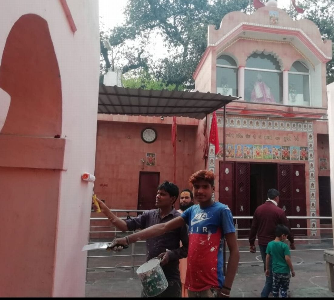 काशीपुर में चैती मंदिर की रंगाई पुताई करते मजदूर।