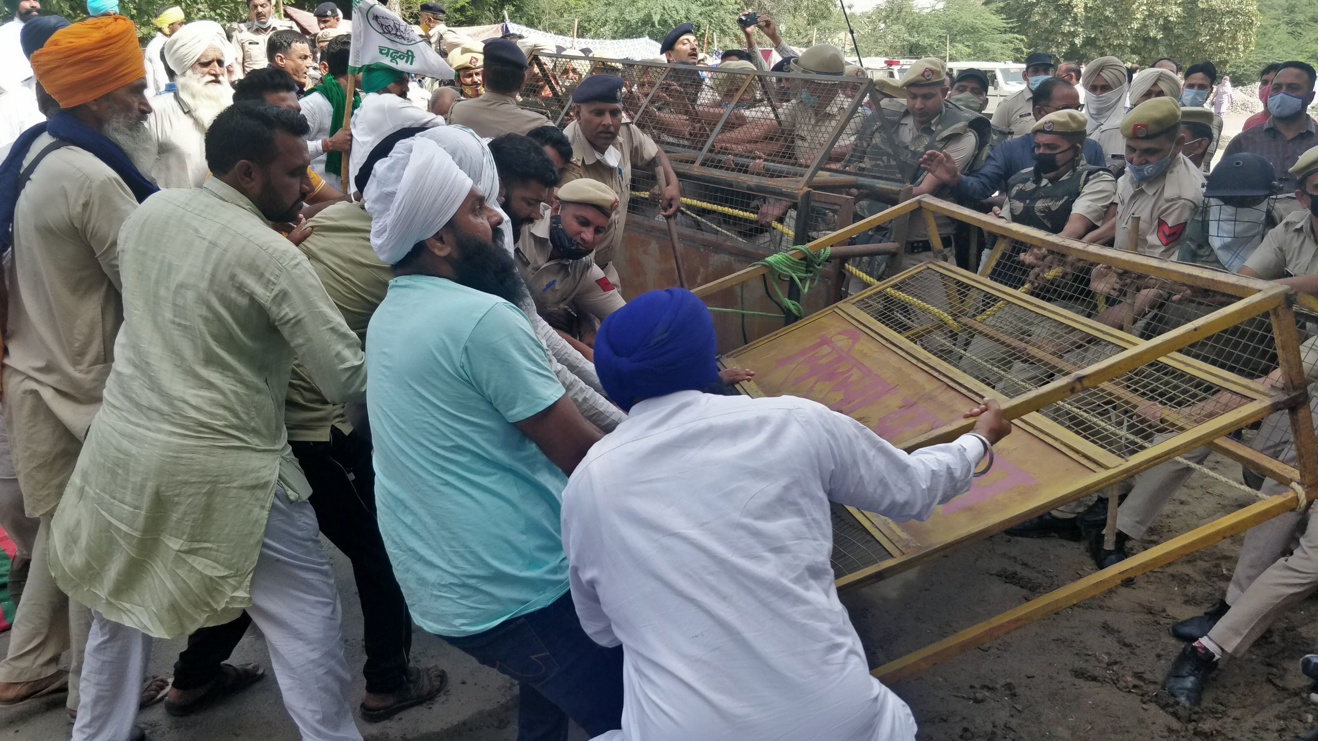 किसान बैरिकेड तोड़ते हुए व पुलिस फोर्स किसानों को रोकते हुए।