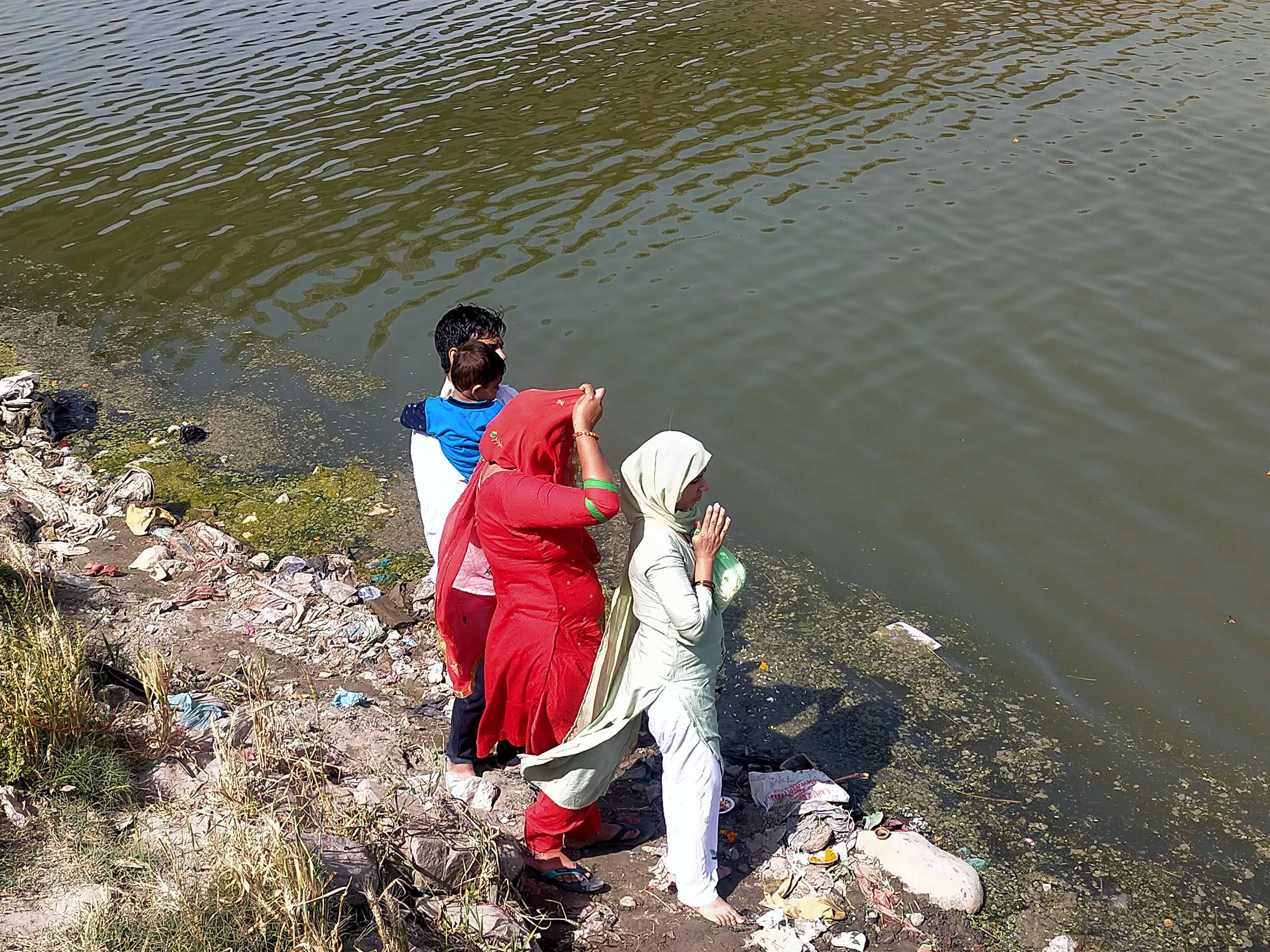 कैराना यमुना नदी तट पर गंदगी के बीच खडे होकर पूजा करते श्रद्धालु कैराना यमुना नदी तट पर गंदगी के बीच खडे होकर पूजा करते श्रद्धालु