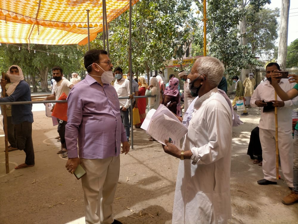 कैराना के कंडेला में वोटर लिस्ट में प्रत्याशी का नाम नही होने पर एसडीएम से वार्ता करता ग्रामीण