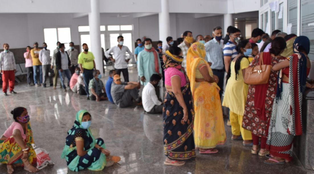 रुद्रपुर में पंजीकरण के लिए लगी लाइन के दौरान थककर जमीन पर बैठे बुजुर्ग। रुद्रपुर में पंजीकरण के लिए लगी लाइन के दौरान थककर जमीन पर बैठे बुजुर्ग।