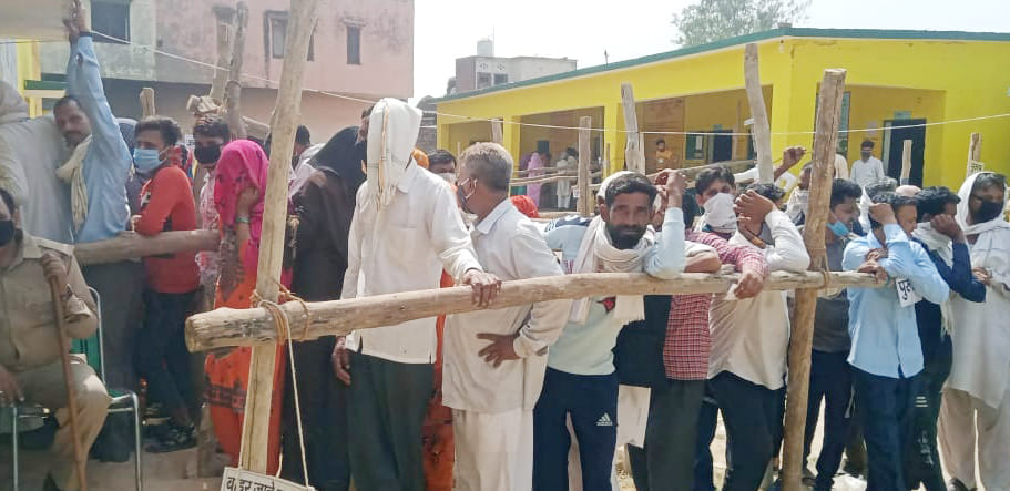 तलहेड़ी में एक पोलिंग बूथ पर कतारों में वोट को खड़े मतदाता