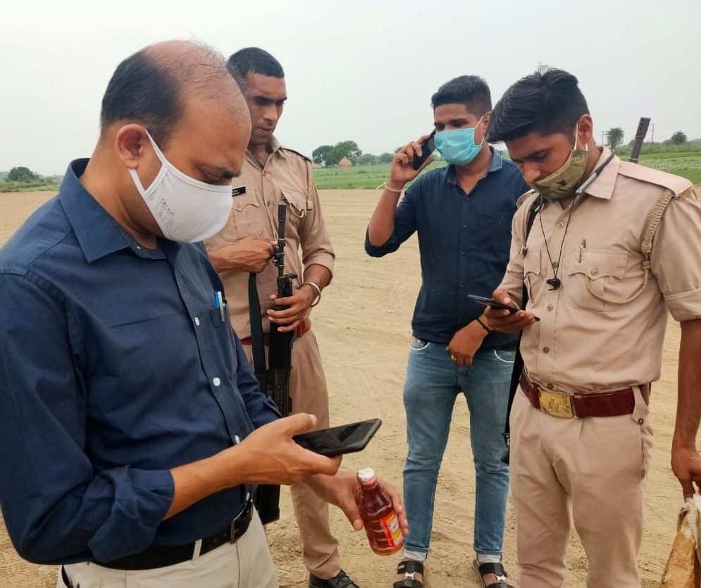 हाथरस : बस्तोई के रजबहे से बरामद शराब के क्वार्टर का नमूना लेते जिला आबकारी अधिकारी।