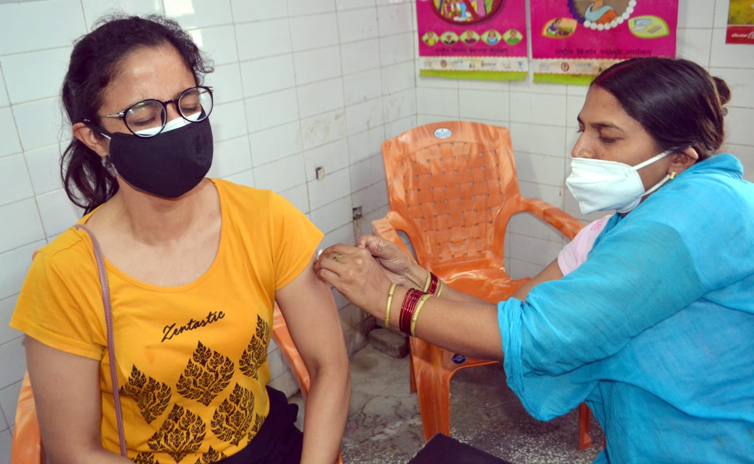 महिला अस्पताल में युवती को कोरोना टीका लगाती नर्स। संवाद