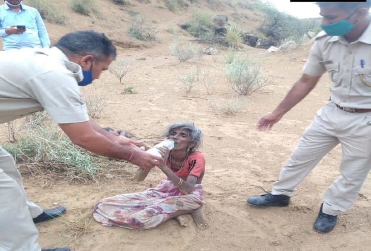 बुजुर्ग महिला को पानी पिलाते पुलिसकर्मी