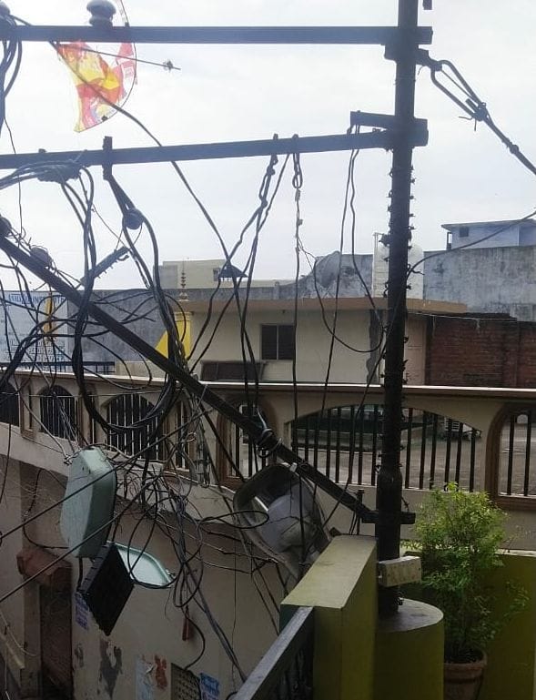 मोहल्ला चरक का कुआ में एक मकान के छज्जे पर रखा एचटी लाइन का पोल।