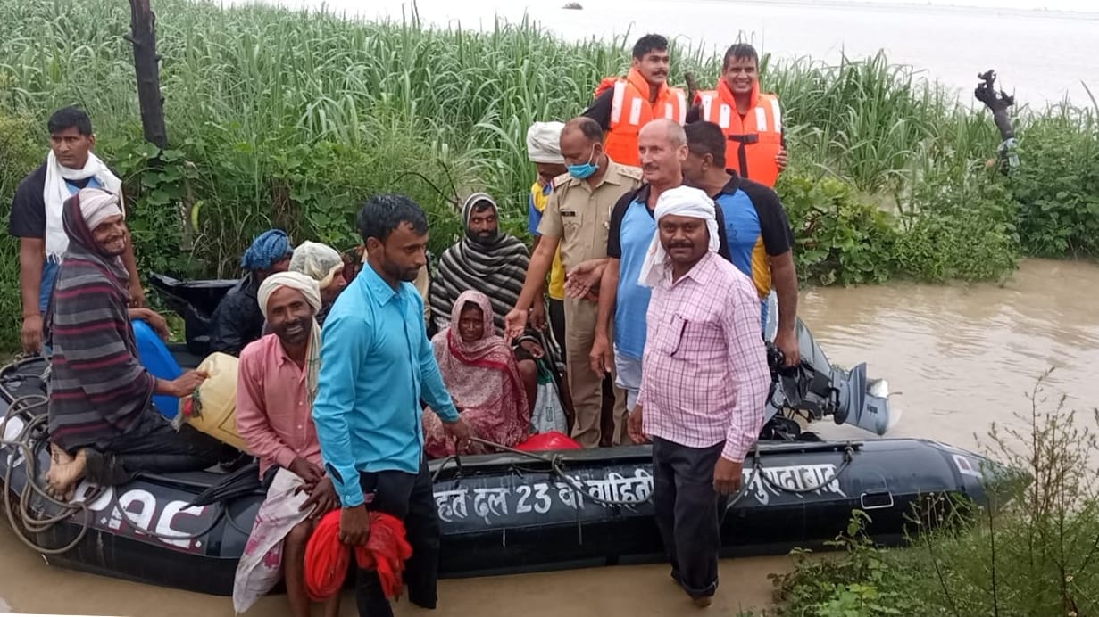 मंडावर के गांव सिमली में गंगा में फंसे ग्रामीणों को मोटर वोट से बचाकर लाते पीएएसी के जवान।