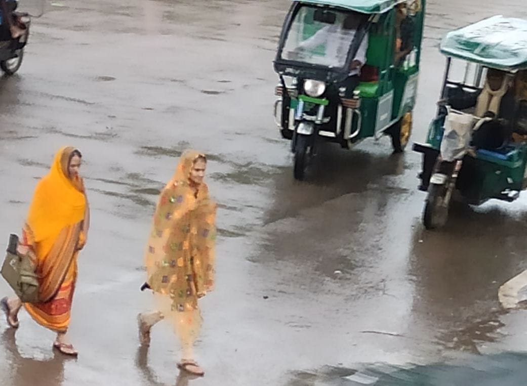 शहर में हुई झमाझम बारिश के बीच गुजरते लोग। संवाद शहर में हुई झमाझम बारिश के बीच गुजरते लोग। संवाद