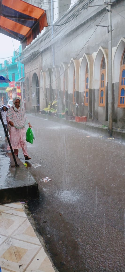 मेंढर में झमाघम बारिश के बीच बाजार से गुजरती महिला मेंढर में झमाघम बारिश के बीच बाजार से गुजरती महिला