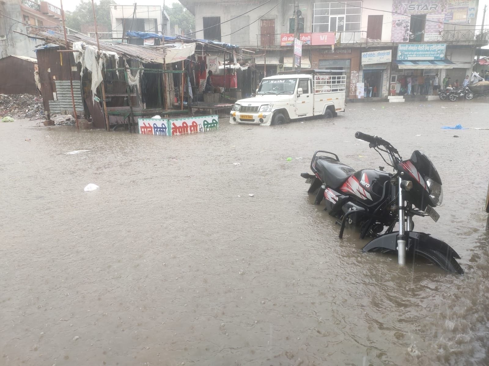 तोशाम के मुख्य बाजार में भरा बारिश के पानी में डूबे वाहन। संवाद तोशाम के मुख्य बाजार में भरा बारिश के पानी में डूबे वाहन। संवाद