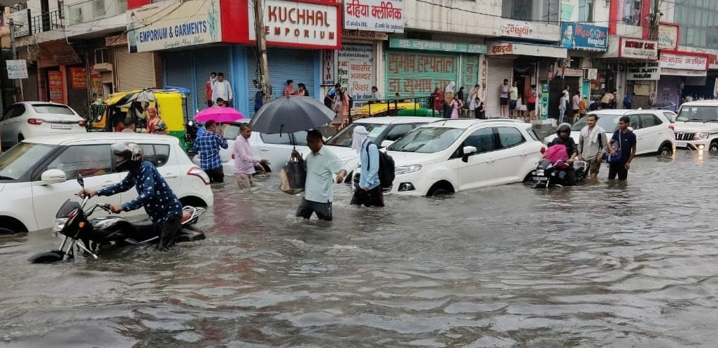 गोहाना रोड पर कई फुट तक भरे बारिश के पानी के बीच खड़े वाहन। संवाद