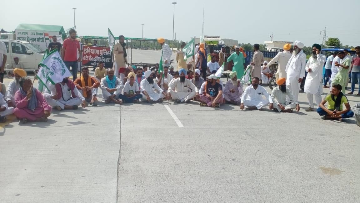 खुईया मलकाना टोल प्लाजा को बंद कर सड़क के बीच बैठे किसान। खुईया मलकाना टोल प्लाजा को बंद कर सड़क के बीच बैठे किसान।
