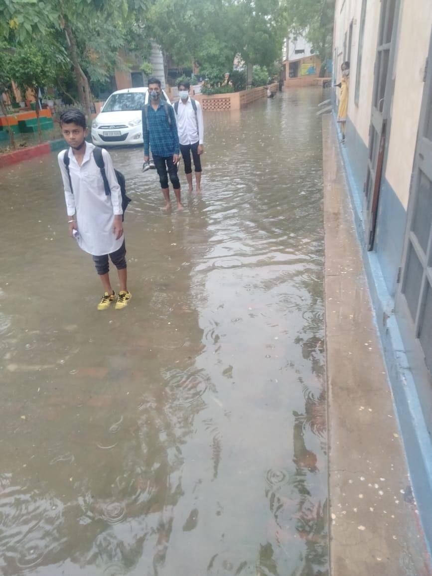 बारिश के बीच स्कूल पहुंचे विद्यार्थी।