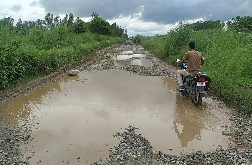 भागूवाला-चंदक हेड मार्ग पर जलभराव से गुजरते राहगीर।