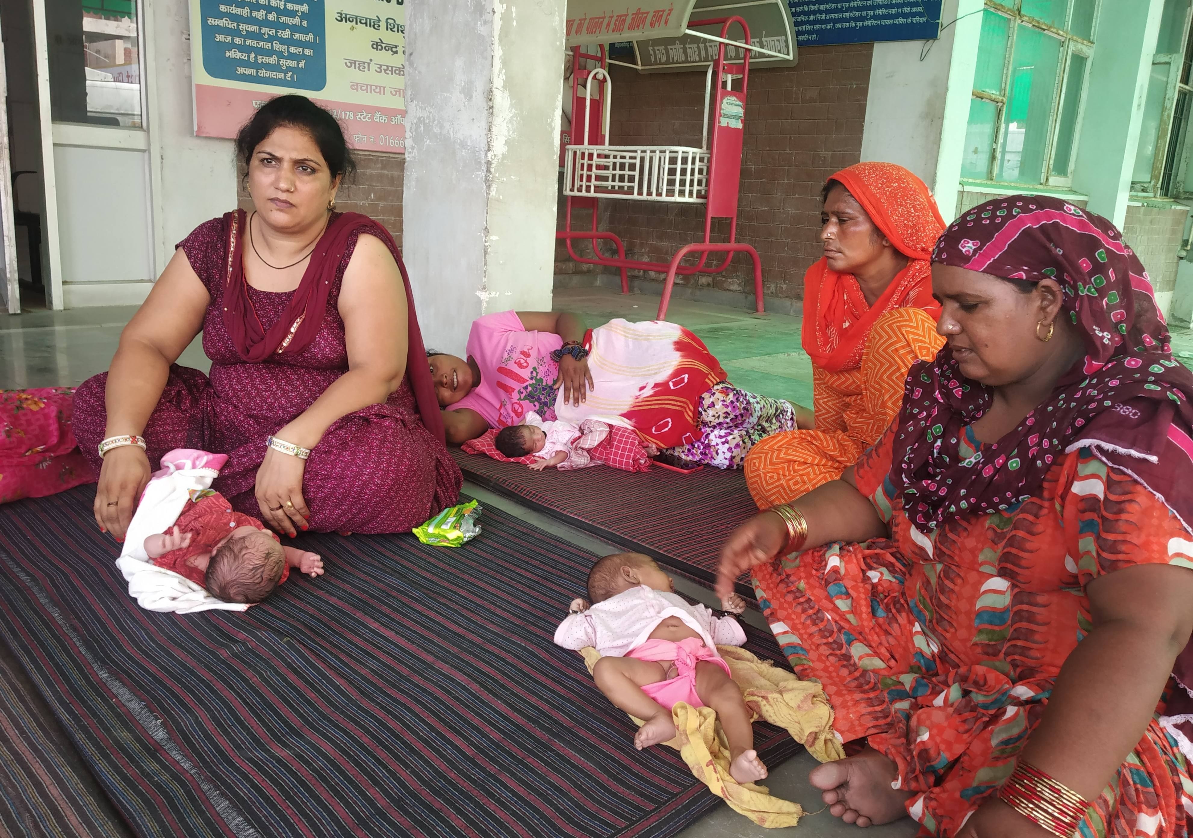 आपातकालीन भवन के बाहर नवजात को लेकर बैठी महिलाएं आपातकालीन भवन के बाहर नवजात को लेकर बैठी महिलाएं