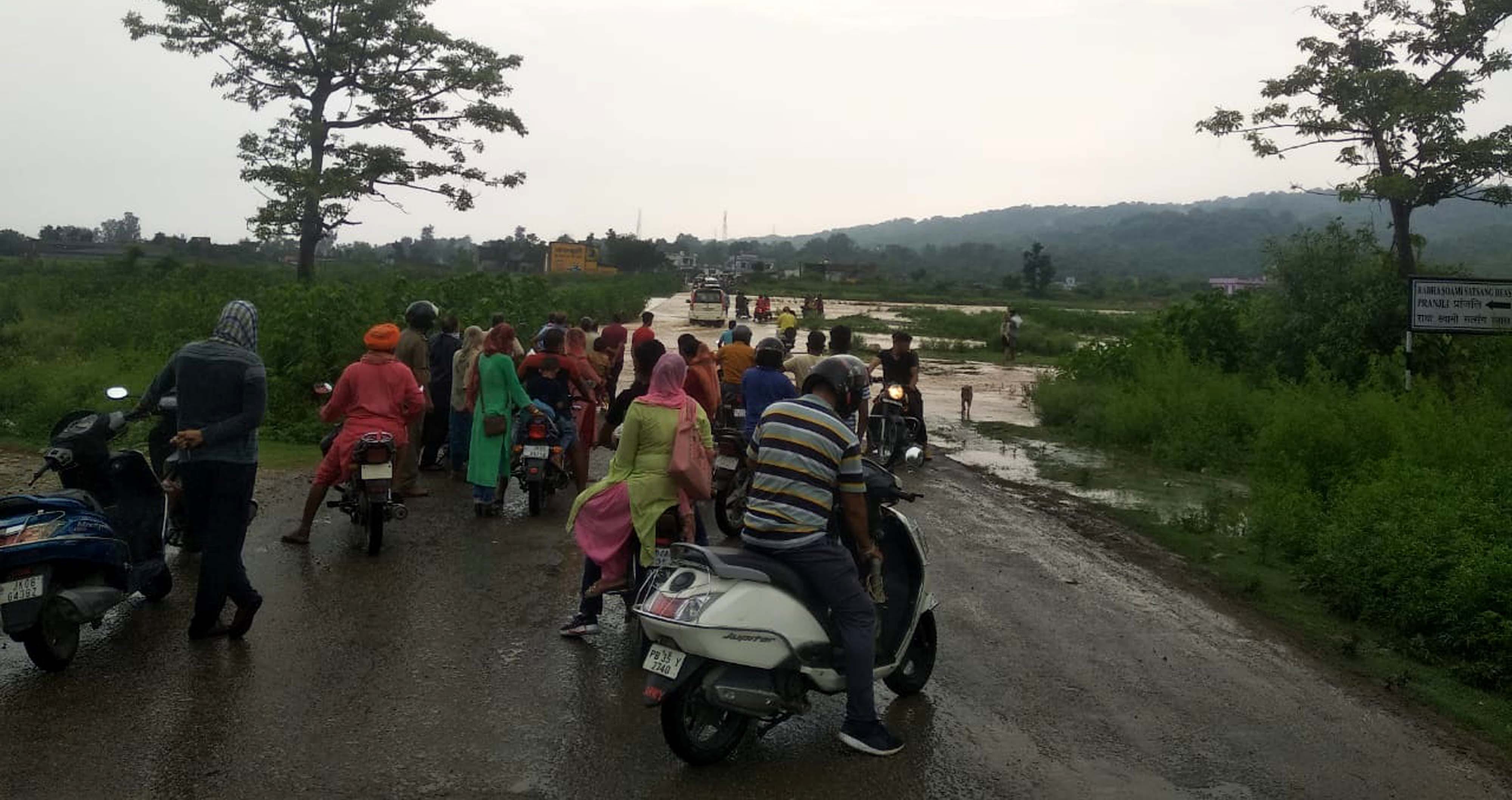 जलस्तर बढ़ने से नाले के एक तरफ खडे वाहन चालक। जलस्तर बढ़ने से नाले के एक तरफ खडे वाहन चालक।
