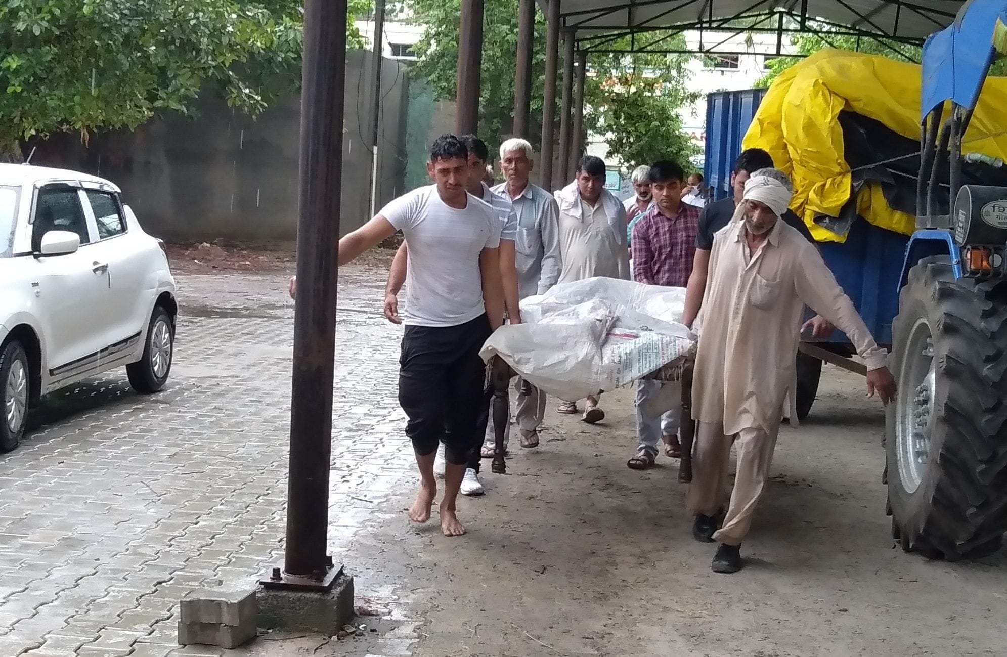किसान के शव को अस्पताल के शवगृह में लेकर पहुंचे परिजन।