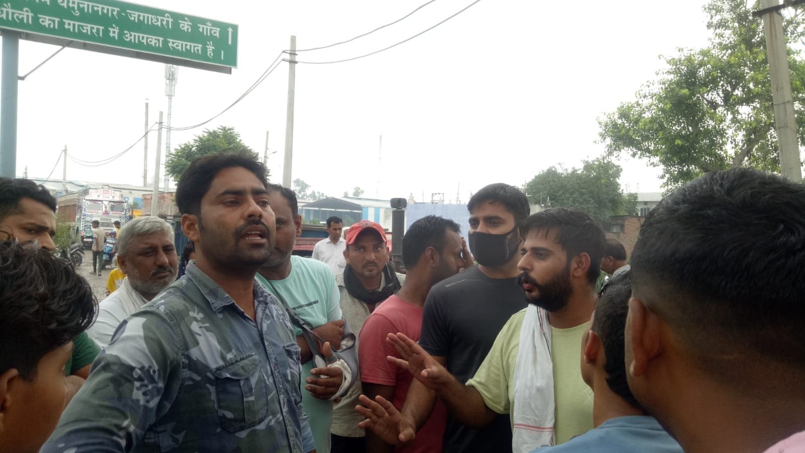 बाड़ी माजरा में समझाने आए ठेकेदार को घेरे खड़े लोग।   संवाद