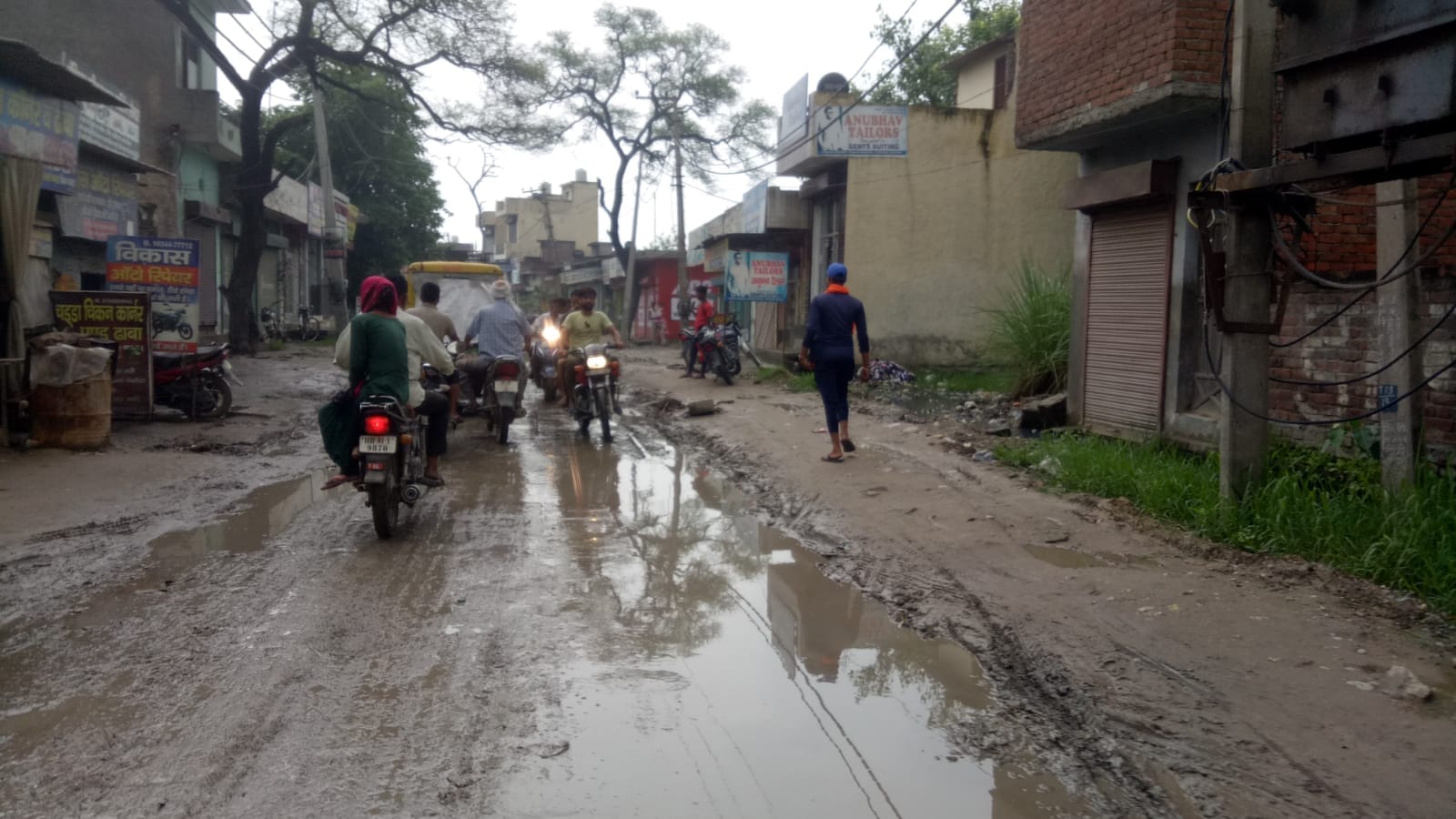 बाड़ी माजरा में सड़क पर जमा पानी व कीचड़ से निकलते लोग।    संवाद