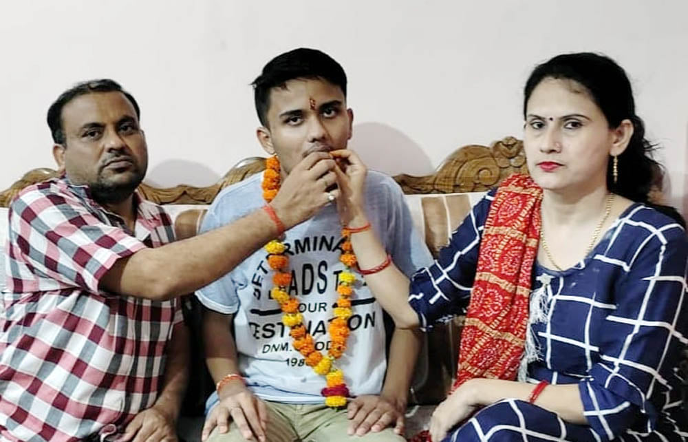 आर्यन तिवारी को मुंह मीठा कराते माता शारदा तिवारी व पिता राजेश तिवारी।