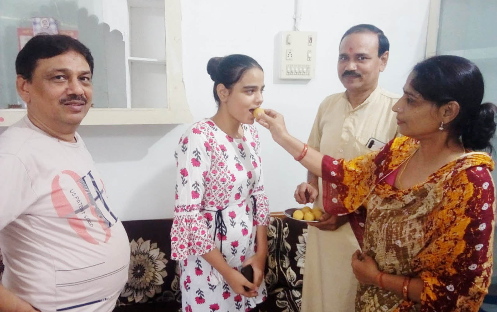 कौशिकी शुक्ल को मुंह मीठा कराते माता पिता व अन्य।