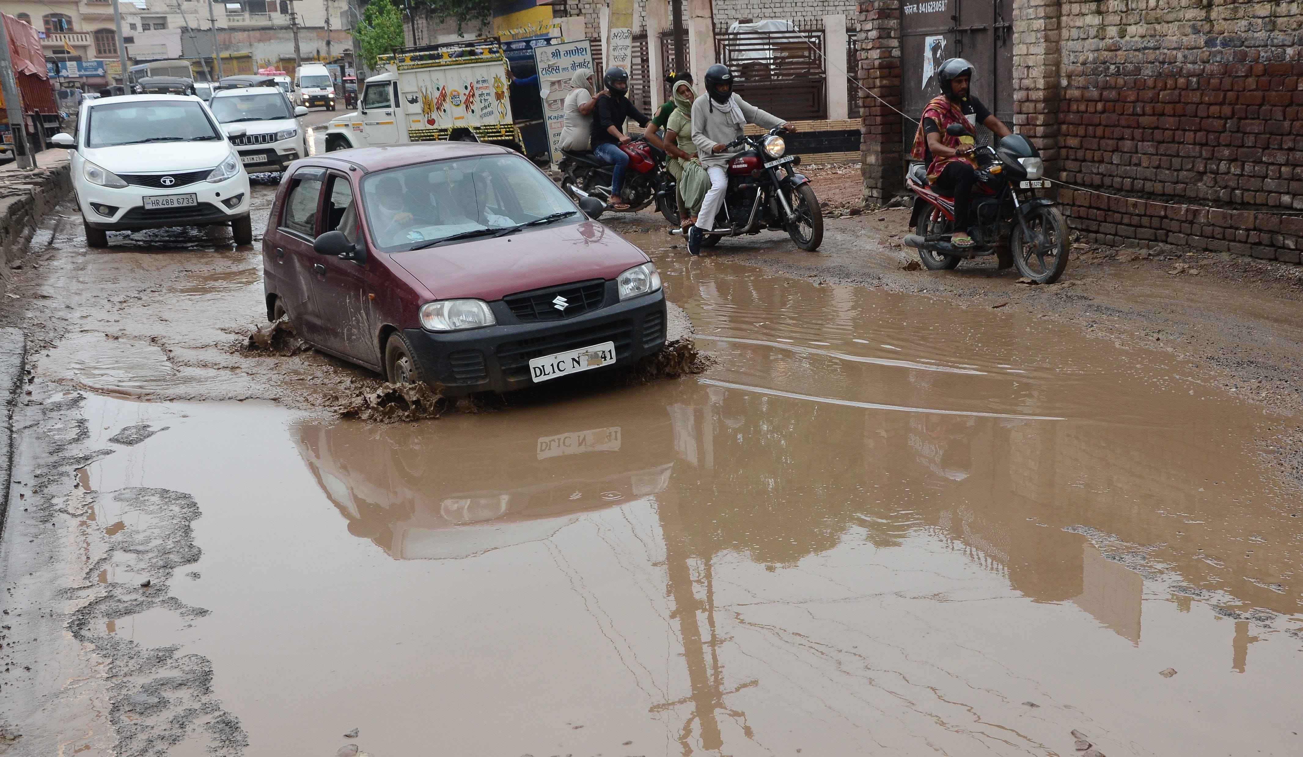 नेशनल हाईवे की टूटी सड़क से निकलते वाहन । संवाद नेशनल हाईवे की टूटी सड़क से निकलते वाहन । संवाद