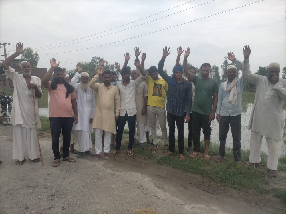 कैराना के बसेडा में बरसात के पानी से धान की फसल को हुए नुकसान के मुआवजे की मांग करते किसान