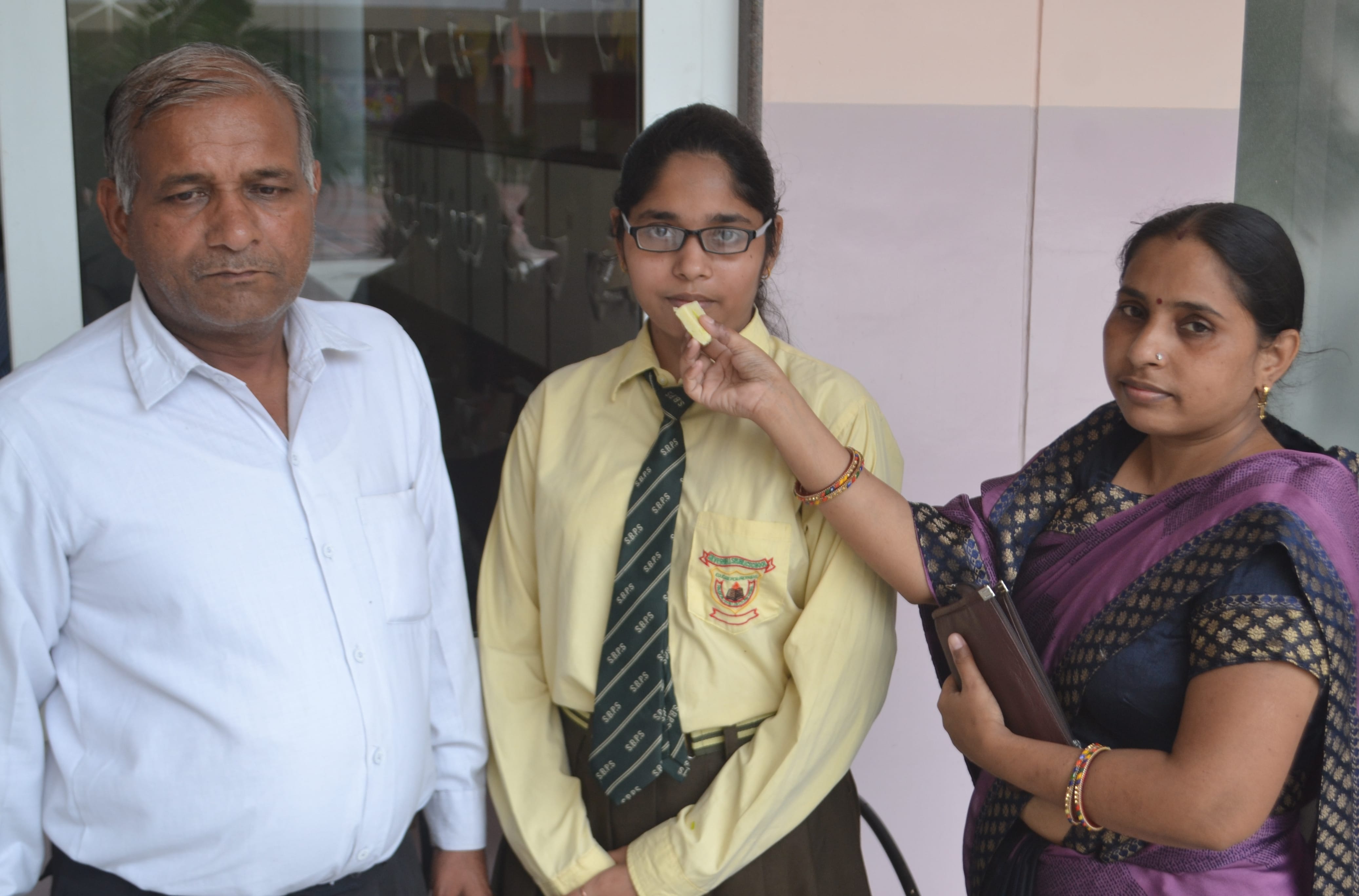 शामली के सिल्वर बेल्स स्कूल में सीबीएसई इंटर का रिजल्ट आने पर टॉपर छात्रा को मिठाई खिलाते परिजन।