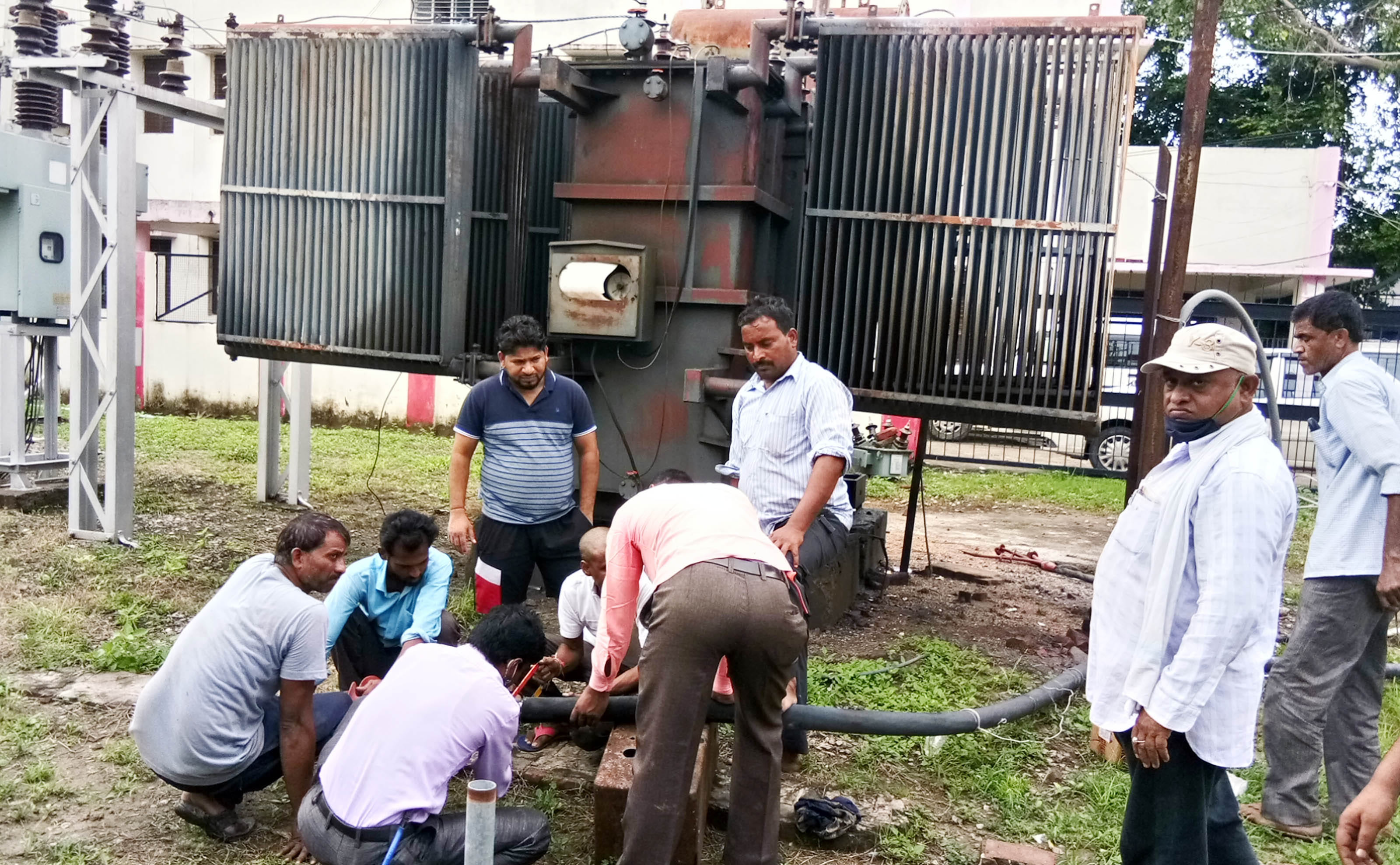 मुख्य पावर हाउस में ट्रांसफार्मर की फुंकी केबिल ठीक करते बिजली कर्मी।