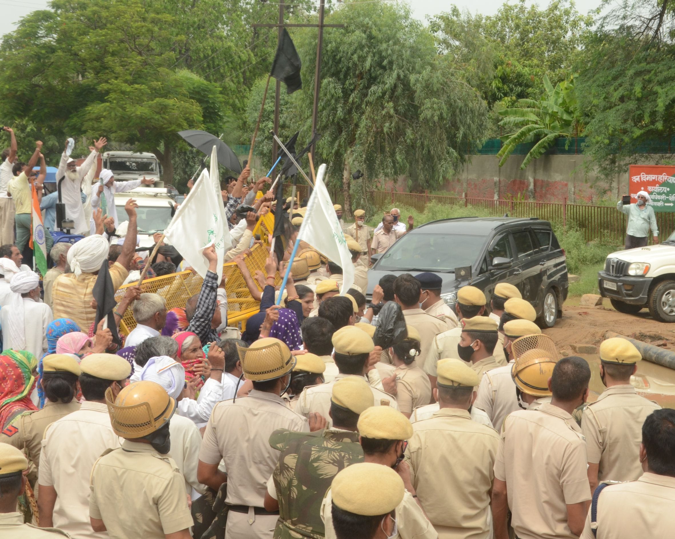    इनोवा में सवार होकर जा रही बबीता फौगाट को काले झंडे दिखाकर विरोध करते किसान।