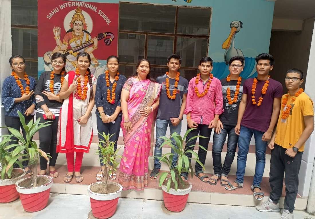 साहू इंटरनेशनल स्कूल में मेधावी छात्र-छात्राओं को माला पहनाकर खुशी का इजहार करती प्रधानाचार्या 