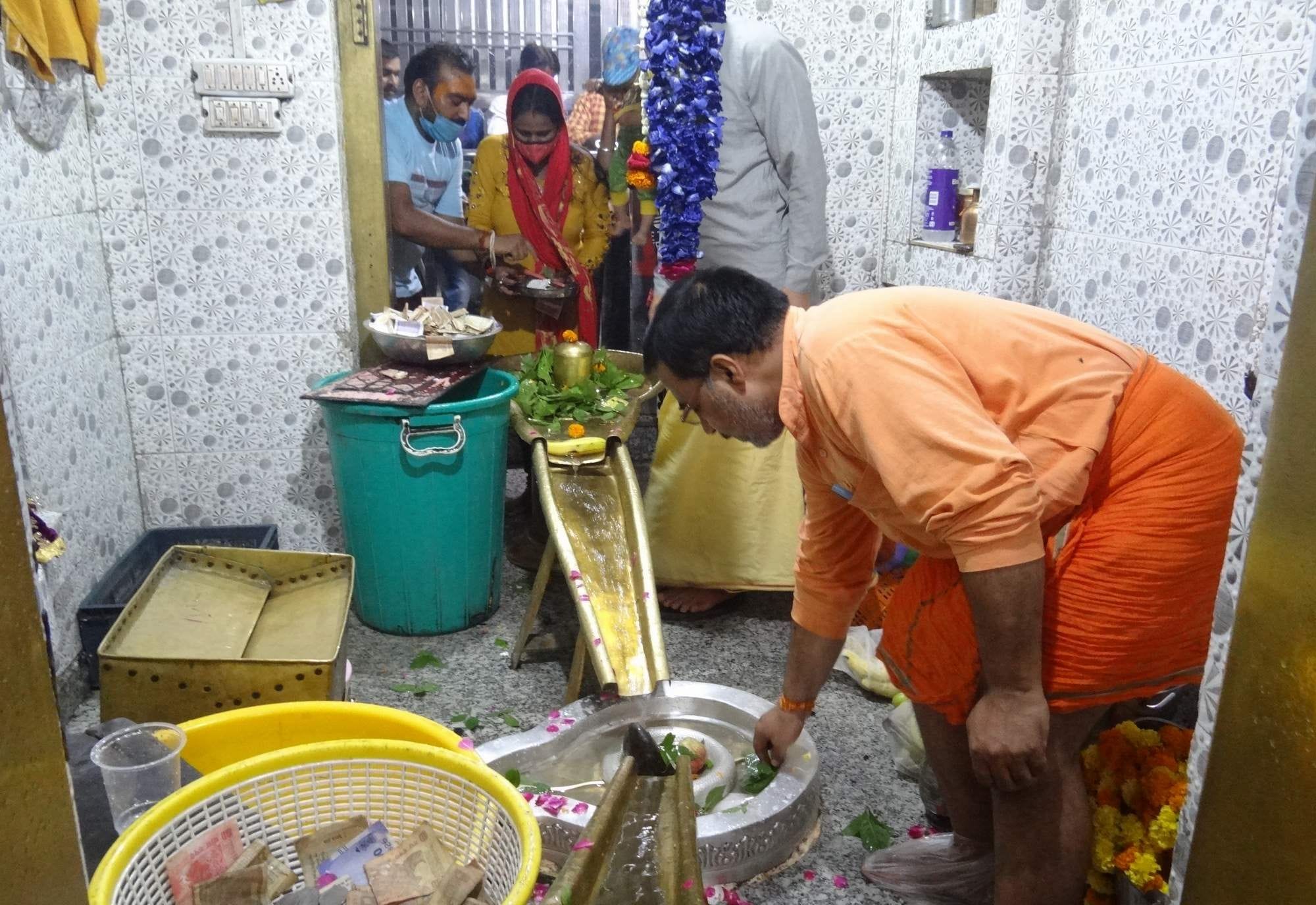 नीलकंठ मंदिर में जलाभिषेक करते शिवभक्त।