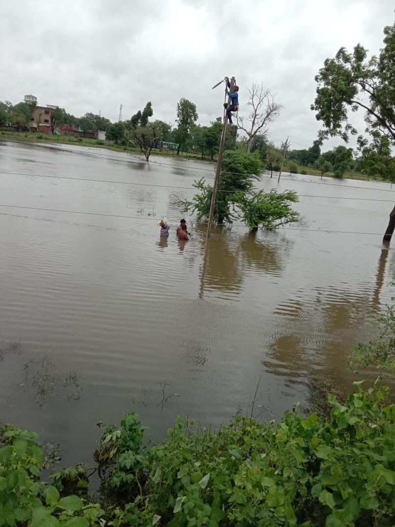 खेतों में भरे पानी के बीच में जाकर हाइटेंशन लाइन के तार सुधारते बिजली कर्मचारी। खेतों में भरे पानी के बीच में जाकर हाइटेंशन लाइन के तार सुधारते बिजली कर्मचारी।