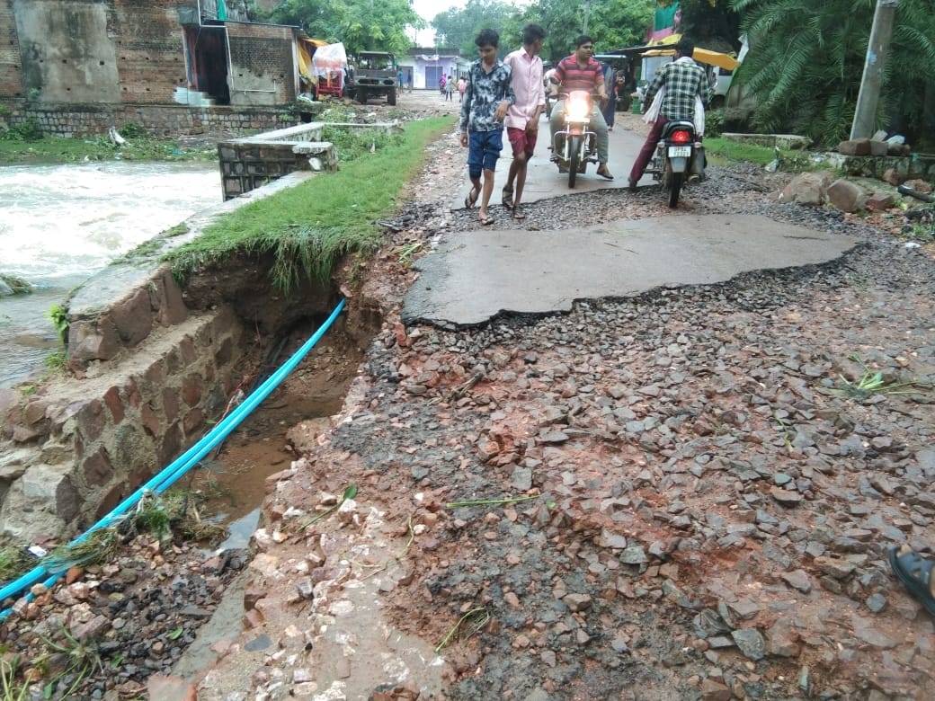 नदी के तेज बहाव में उखड़ गई पुल के किनारे की सड़क।