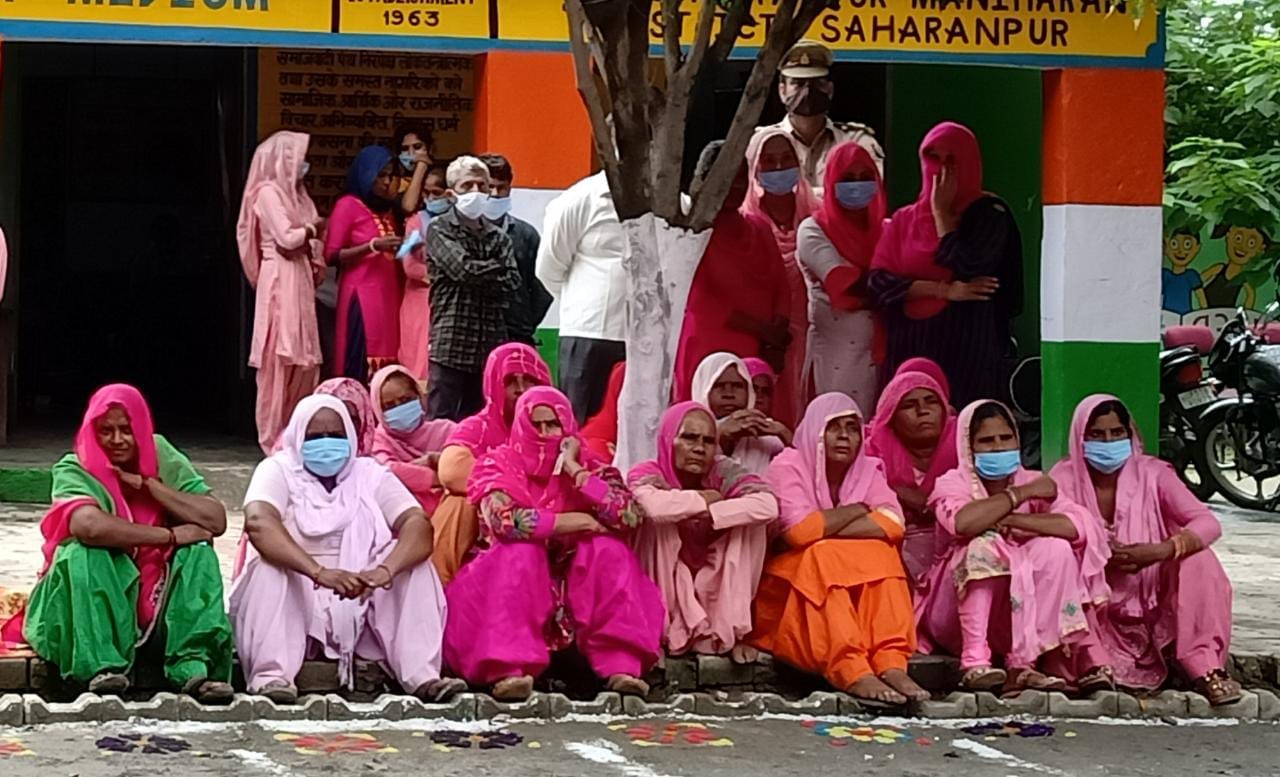 जमीन पर बैठ कर पीएम का संवाद सुनती महिलाएं जमीन पर बैठ कर पीएम का संवाद सुनती महिलाएं
