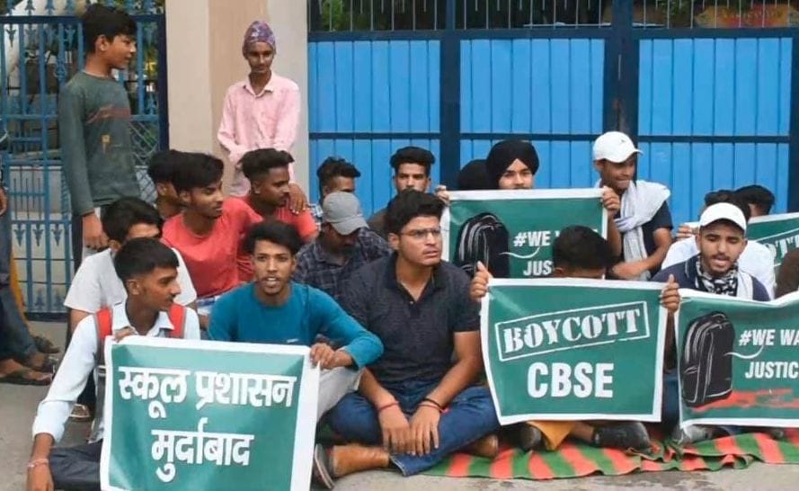 स्कूल के समक्ष धरना देकर बैठे विद्यार्थी।