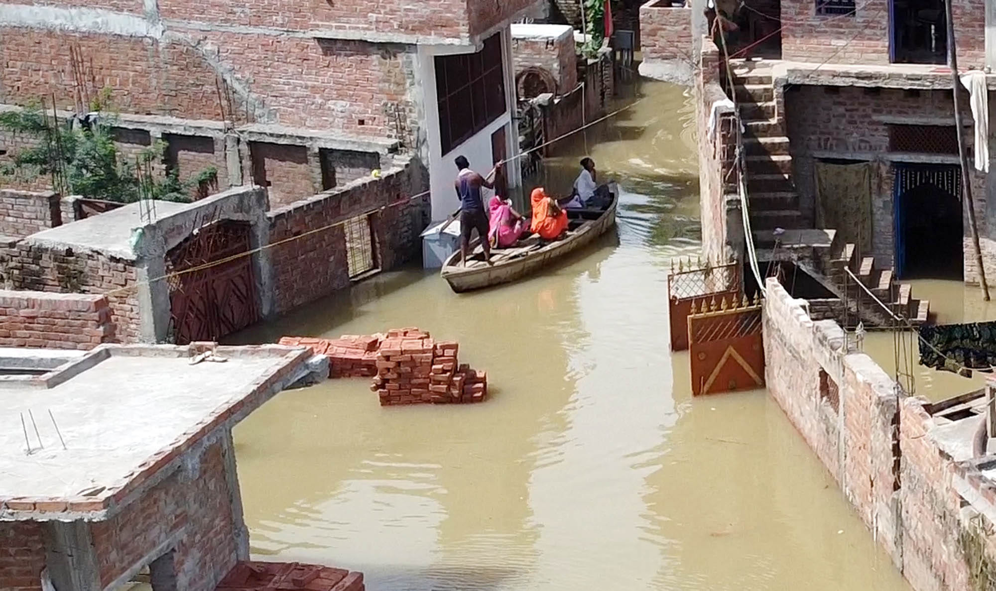 शहर में नाव पर बैठकर निकलते बाढ़ पीड़ित। शहर में नाव पर बैठकर निकलते बाढ़ पीड़ित।
