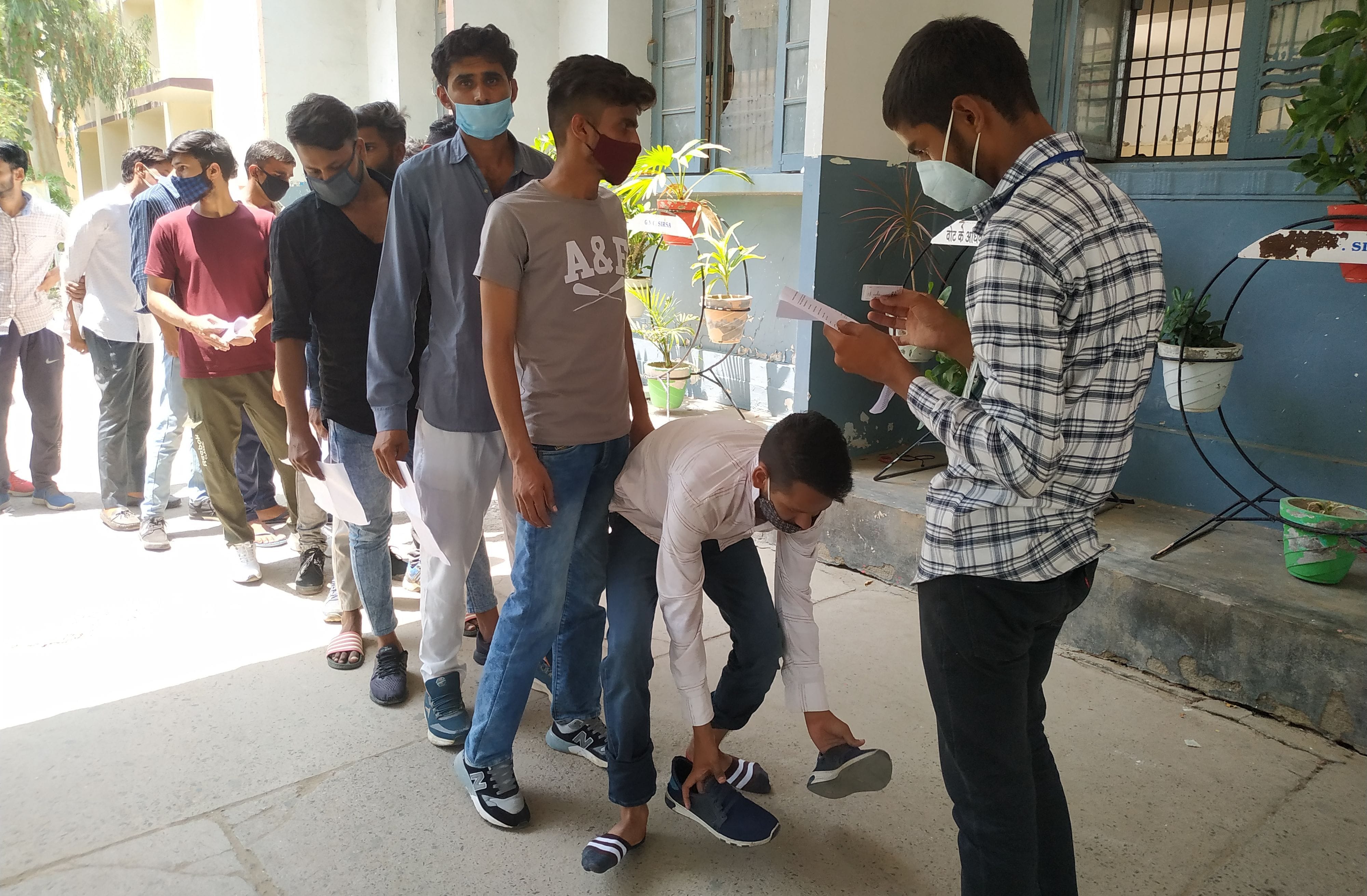 परीक्षार्थी की चेकिंग करते हुए चेकिंग टीम सदस्य।